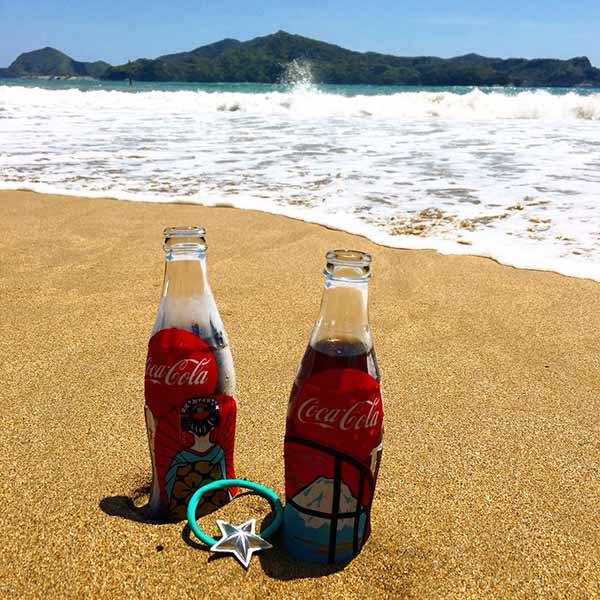 浜辺においてある2本のコーラ